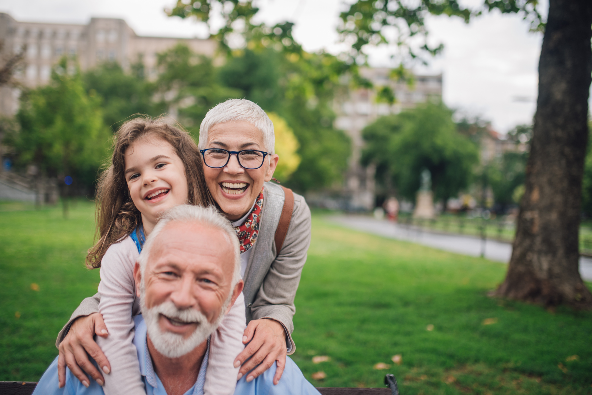 Happy grandparents hugging with granddaughter